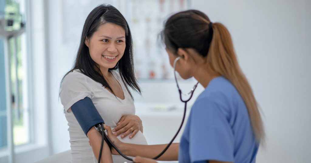 pregnant women being assisted by the nurse in checking the blood pressure
