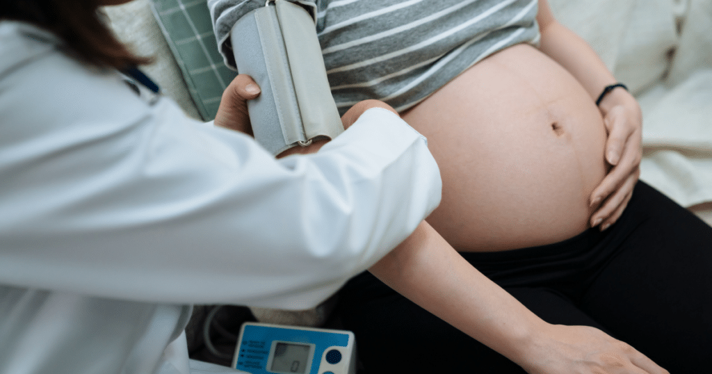 pregnant woman being checked by the doctor, blood pressure equipment being wrapped around her right arm